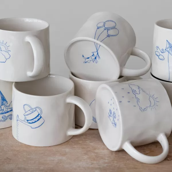 imageCreative CoOp Stoneware Wax Relief Illustration and Secret Image on Bottom Cream and Blue Set of 8 Styles Mugs Multi