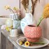imageCreative CoOp Embossed TerraCotta Footed VasePlanter with Crackle Glaze Coral